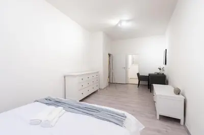 a white bedroom with a bed and a desk at Timeless Charming Studio near Old Town in Prague