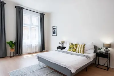 a bedroom with a large bed and a large window at Unique Old Town 2BR Oasis with Sofa Bed in Prague