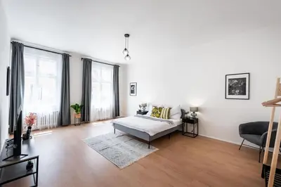 a living room with a couch and two windows at Unique Old Town 2BR Oasis with Sofa Bed in Prague