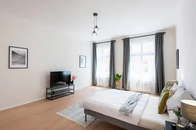 a white living room with a couch and a tv at Unique Old Town 2BR Oasis with Sofa Bed in Prague