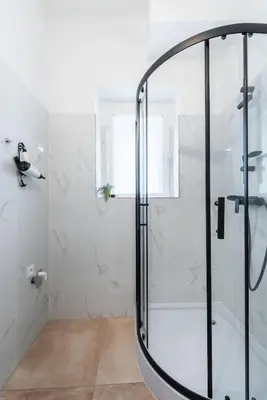 a shower with a glass door in a bathroom at Urban 2BR Haven with Sofa Bed in Central Prague in Prague