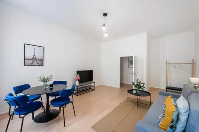 a living room with a blue couch and a table at Urban 2BR Haven with Sofa Bed in Central Prague in Prague