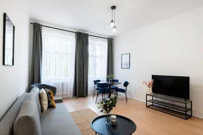 a living room with a couch and a television at Urban 2BR Haven with Sofa Bed in Central Prague in Prague