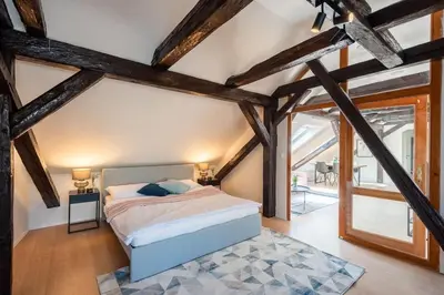 a bedroom with a bed in a room with wooden beams at Wonderful Romantic Old Town Apt in Prague