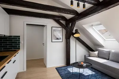 a living room with a couch and a table at Under the Beams - Designer Prague Old Town Loft in Prague