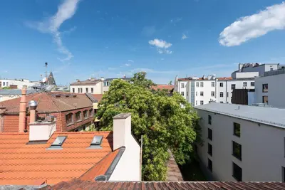 a view of a city with roofs and buildings at Under the Beams - Designer Prague Old Town Loft in Prague