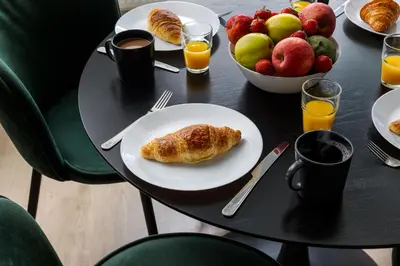a table with a plate of food and a bowl of fruit at Under the Beams - Designer Prague Old Town Loft in Prague