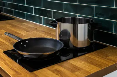 a pot sitting on top of a stove next to a sink at Under the Beams - Designer Prague Old Town Loft in Prague