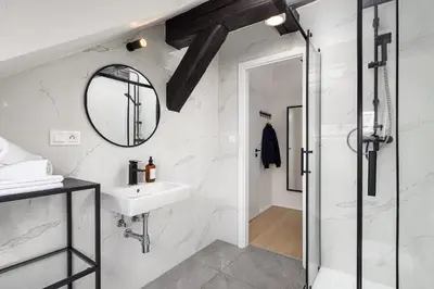 a bathroom with a sink and a mirror at Under the Beams - Designer Prague Old Town Loft in Prague