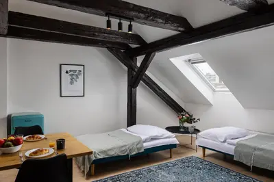 a attic room with two beds and a table at Zesty Family Friendly Elevator Access Old Town in Prague