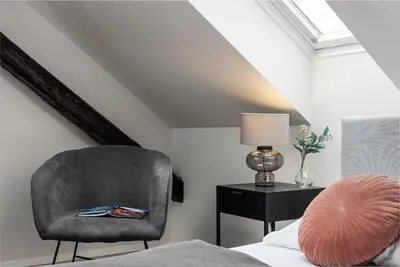 a bedroom with a chair and a table with a lamp at Zesty Family Friendly Elevator Access Old Town in Prague