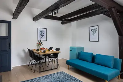 a living room with a blue couch and a table at Zesty Family Friendly Elevator Access Old Town in Prague