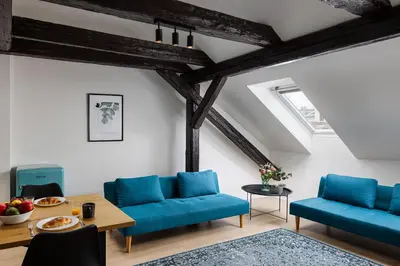 a living room with blue chairs and a table at Zesty Family Friendly Elevator Access Old Town in Prague
