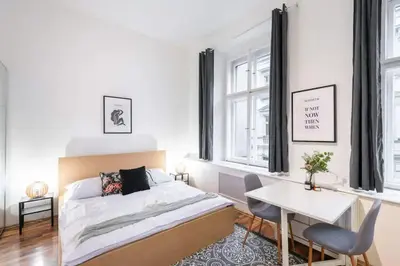a bedroom with a bed and a table and a desk at Friendly Studio for Two Old Town in Prague