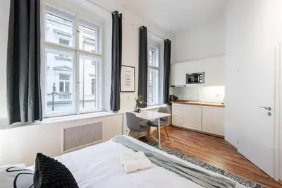 a bedroom with a bed and a kitchen with windows at Friendly Studio for Two Old Town in Prague