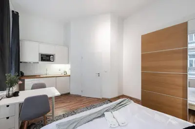 a bedroom with a bed and a desk and a kitchen at Friendly Studio for Two Old Town in Prague
