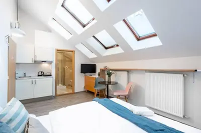 a bedroom with a large bed and a kitchen at Delightful Old Town Studio in Prague