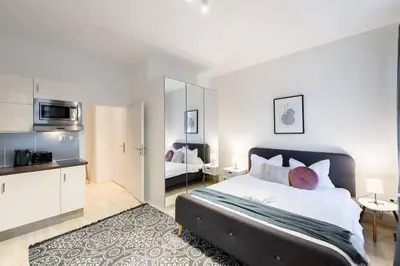 a bedroom with a large bed and a kitchen at Welcoming Studio in Historic Prague in Prague