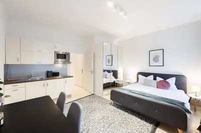 a bedroom with a large bed and a kitchen at Welcoming Studio in Historic Prague in Prague