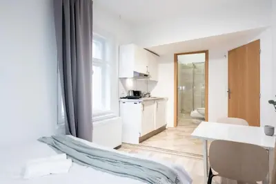 a white room with a kitchen and a table at Peaceful Chic Studio in Central Prague in Prague