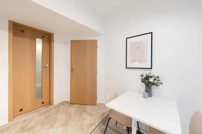 a white room with a table and a wooden door at Peaceful Chic Studio in Central Prague in Prague