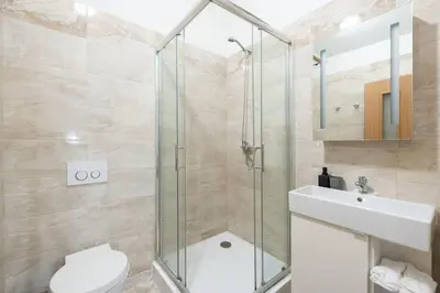 a bathroom with a shower and a toilet and a sink at Elegant 4-Guest Retreat near Old Town in Prague