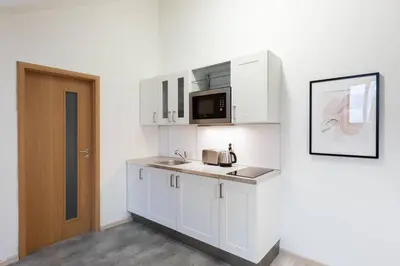 a white kitchen with a sink and a microwave at Elegant 4-Guest Retreat near Old Town in Prague