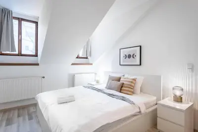 a white bedroom with a white bed and a window at Elegant 4-Guest Retreat near Old Town in Prague