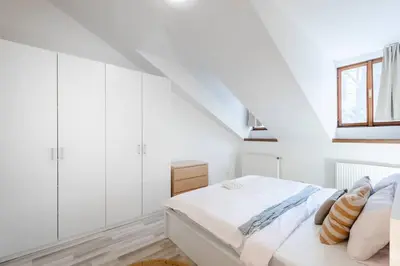 a white bedroom with a bed and a window at Elegant 4-Guest Retreat near Old Town in Prague