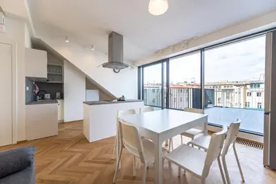 a kitchen and dining room with a white table and chairs at Apartments Seifertova in Prague