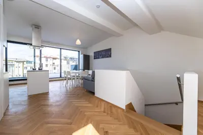 a kitchen and living room with white walls and wooden floors at Apartments Seifertova in Prague