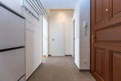 a hallway with white walls and a door and a hallwayngth at Apartments Seifertova in Prague