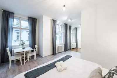 a bedroom with a bed and a table with chairs at Tranquil Prague Studio Gem in Prague