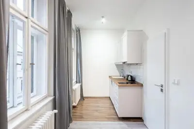 a kitchen with white cabinets and a counter top at Tranquil Prague Studio Gem in Prague