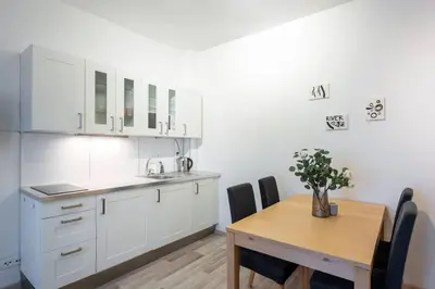 a kitchen with white cabinets and a wooden table at Charming Spacious Apartment in Central Prague in Prague