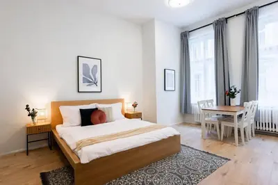 a bedroom with a bed and a table and a chair at Elegant Spacious Old Town Studio in Prague