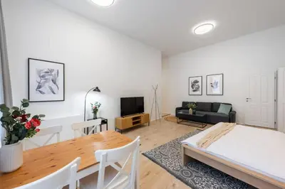 a living room with a bed and a table at Elegant Spacious Old Town Studio in Prague