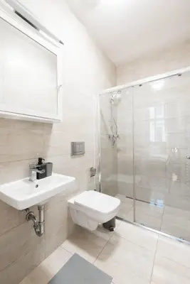 a bathroom with a toilet sink and a shower at Metropolitan Prague Apt with Amenities in Prague