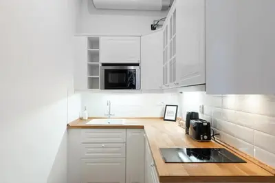 a white kitchen with white cabinets and a sink at Metropolitan Prague Apt with Amenities in Prague