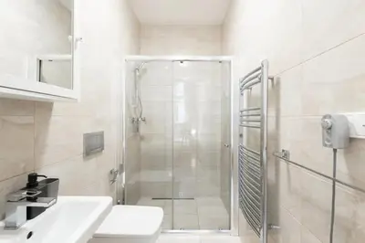 a bathroom with a shower and a toilet and a sink at Metropolitan Prague Apt with Amenities in Prague