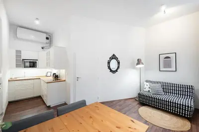 a living room with a couch and a kitchen at Metropolitan Prague Apt with Amenities in Prague