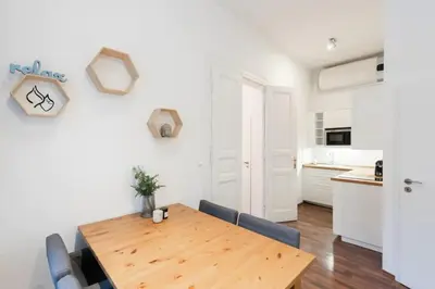 a kitchen and dining room with a wooden table and chairs at Metropolitan Prague Apt with Amenities in Prague