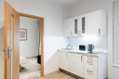 a kitchen with white cabinets and a door open at Neat Cozy Old Town Retreat w Queen Bed in Prague
