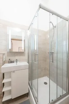 a bathroom with a shower and a sink and a mirror at Romantic Old Town Studio in Prague