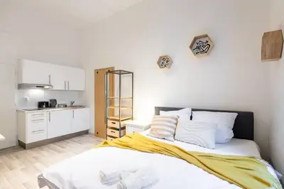 a bedroom with a bed with a yellow blanket on it at Romantic Old Town Studio in Prague