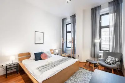 a bedroom with a large bed and a chair at Sunny Old Town Studio in Prague