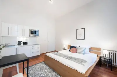 a bedroom with a bed and a kitchen at Sunny Old Town Studio in Prague