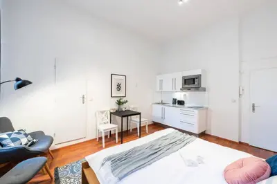 a white living room with a table and a kitchen at Sunny Old Town Studio in Prague