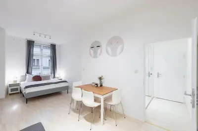 a white room with a bed and a table and chairs at Vast Central Old Town Studio For 3 in Prague