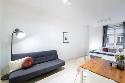 a living room with a blue couch and a table at Vast Central Old Town Studio For 3 in Prague